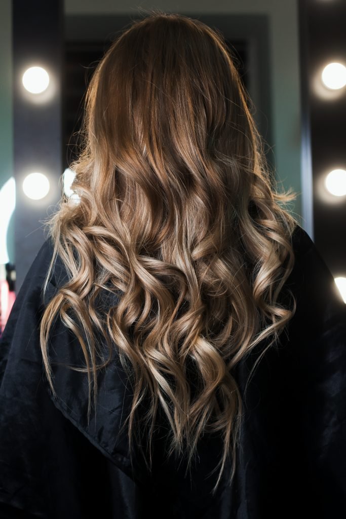 Elegant hair styling. Hair shines and beautifully curled in curl